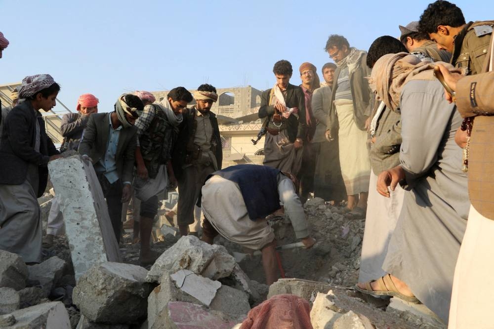 People gather on the rubble of a house hit by a US strike in Saada, on Sunday. REUTERS