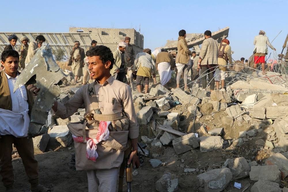 A man holds a fragment of a missile at the site of a US strike in Saada, Yemen, on Sunday. REUTERS