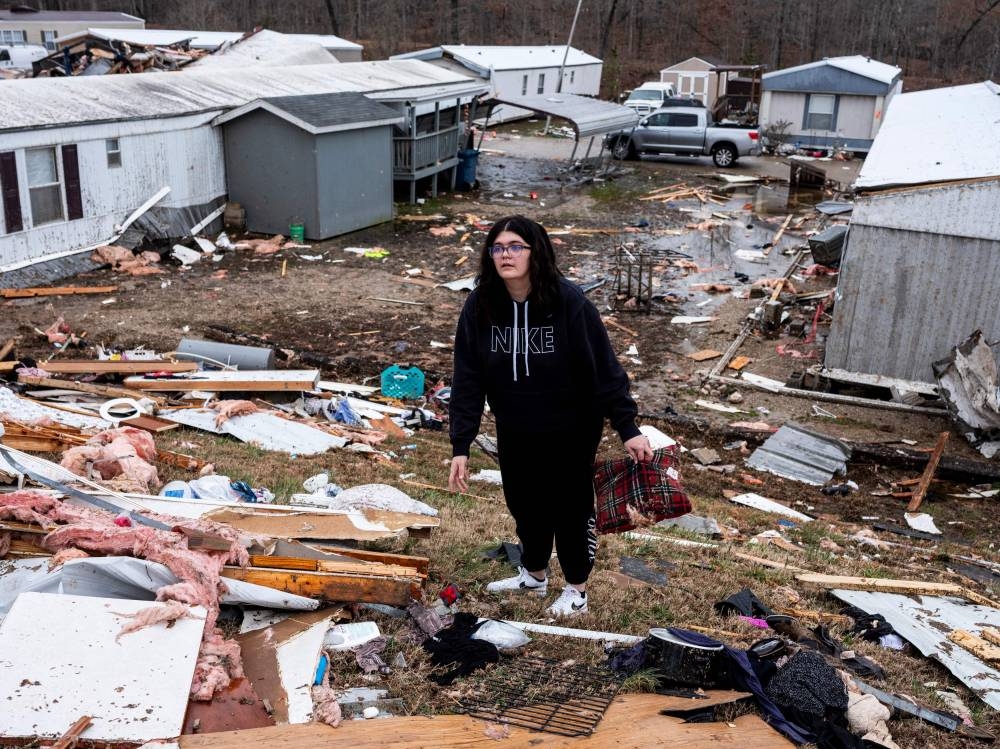 Madison Woodard helps search for her mother's medicine near the destroyed trailer where Madison lived with her mother, Denise Woodard, on Saturday in Poplar Bluff, Missouri. AFP