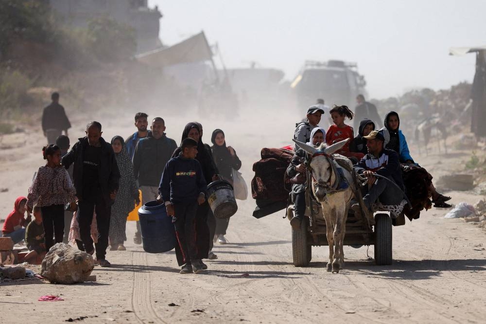 Palestinians make their way to flee their homes, following heavy Israeli strikes, in Beit Lahiya in the northern Gaza Strip, on Tuesday. REUTERS