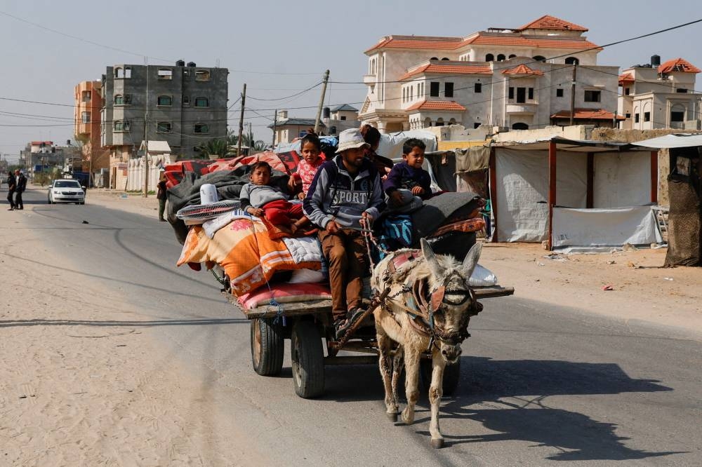 Palestinians make their way to flee their homes, following heavy Israeli strikes, in Rafah in the southern Gaza Strip, on Tuesday. REUTERS