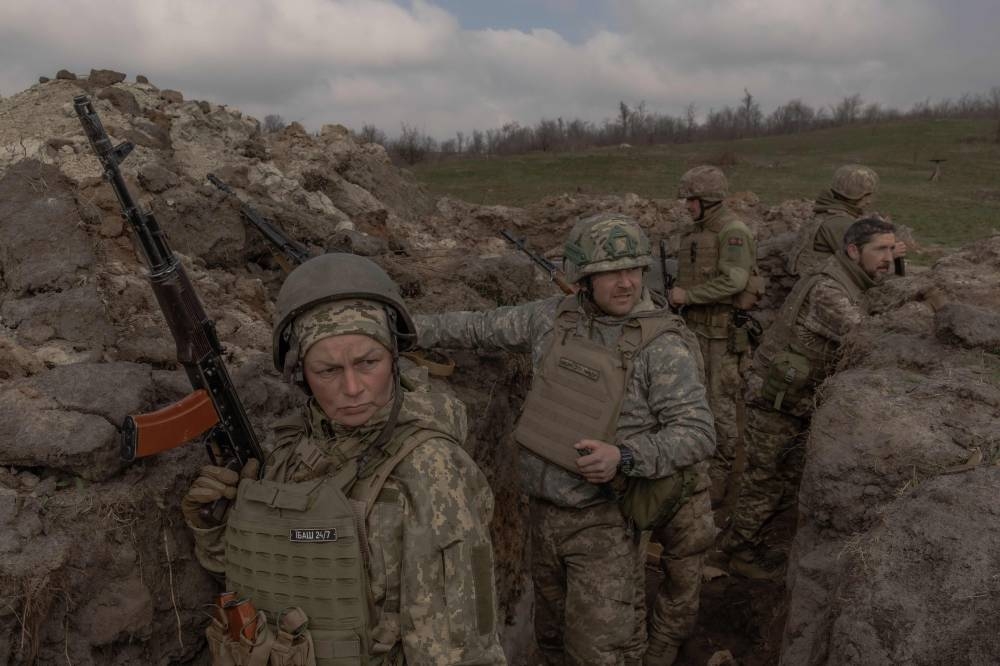 Combat medic and mother of three Natalia (L), 51, serving in the 24th Mechanized Brigade of the Ukrainian Military takes part with other military members in a field training exercise in an undisclosed location in the eastern region of Ukraine, Tuesday.