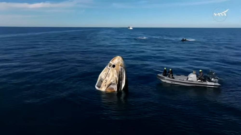 This still image from a NASA+ livestream shows recovery vessels approaching the Dragon capsule with the SpaceX Crew-9 astronauts shortly after splashdown on Tuesday, off the coast of Florida. AFP / NASA