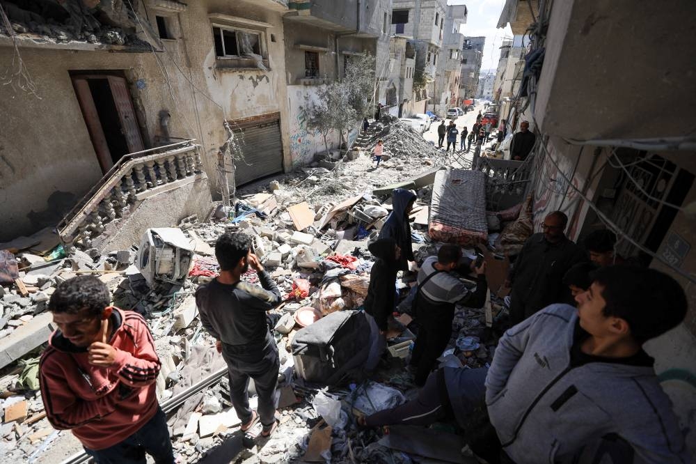 Palestinians gather at the site of an Israeli strike on a residential building in Gaza City, on Wednesday. REUTERS