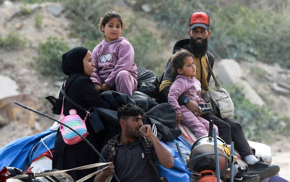 Palestinians make their way to flee their homes, after the Israeli army issued evacuation orders for a number of neighborhoods, following heavy Israeli strikes, in Beit Hanoun in the northern Gaza Strip, on Wednesday. REUTERS