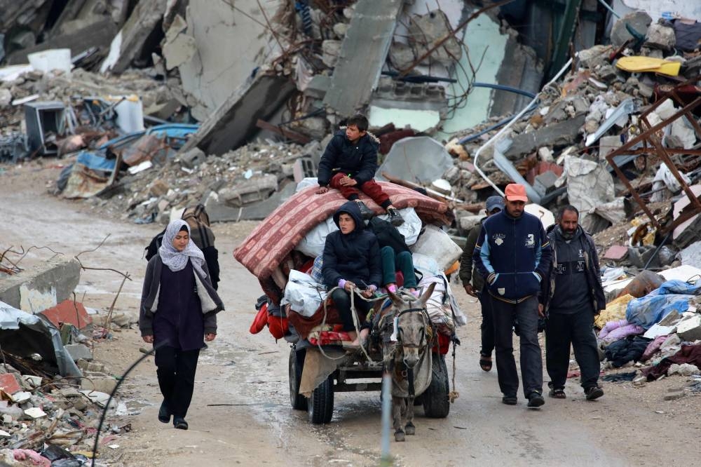 Palestinians use a donkey-pulled cart to transport their belongings as they flee Beit Lahia in the Northern Gaza Strip on Friday. AFP