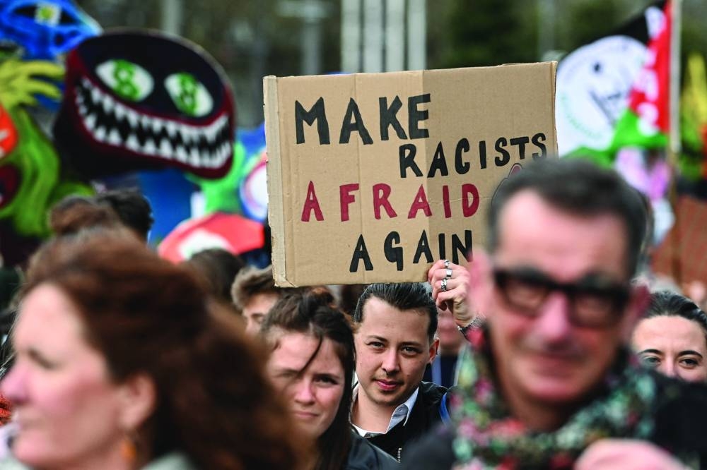 A demonstrator holds a placard reading "Make racists afraid again" during the International Day against Racism and Fascism in Nantes. – AFP