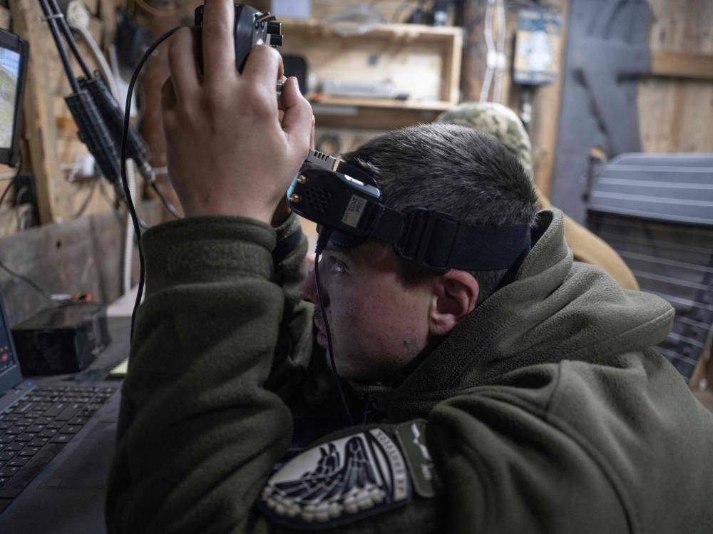 A Ukrainian serviceman operates an FPV drone flying towards Russian positions in the Donetsk region