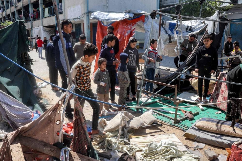 Children stand at the site of a tent that was hit by Israeli bombardment at the Razi school in the Nuseirat camp for Palestinian refugees in the central Gaza Strip, on Monday. AFP
