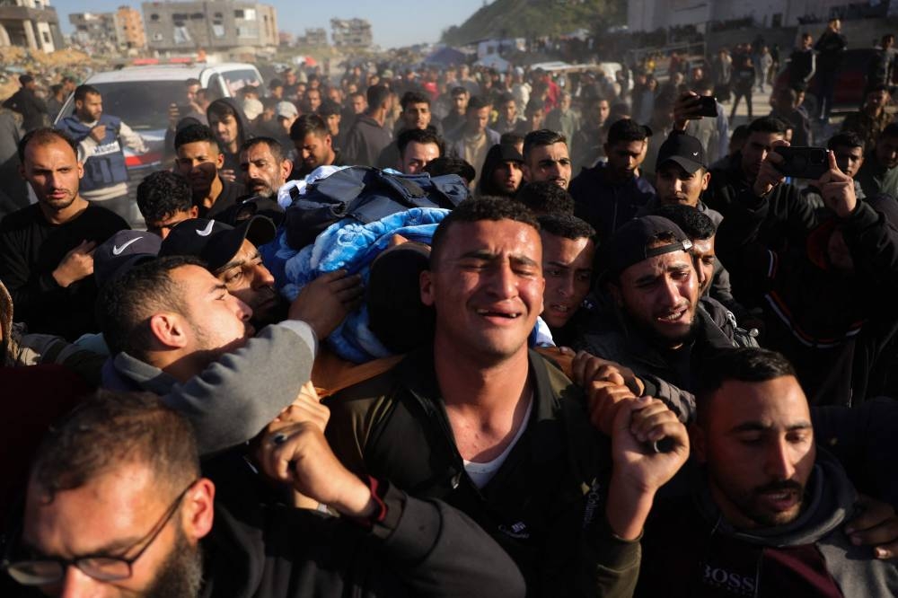 Relatives and colleagues carry the body of Palestinian journalist Hussam Shabat, who collaborated with Al Jazeera Mubasher, during his funeral in Beit Lahia, in the northern Gaza Strip, on Monday. AFP