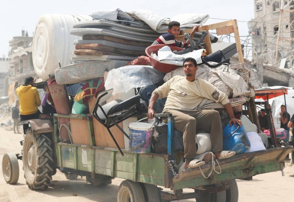 Palestinians make their way with belongings as they flee their homes, after the Israeli army issued evacuation orders, in Jabalia, in the northern Gaza Strip, on Tuesday. REUTERS