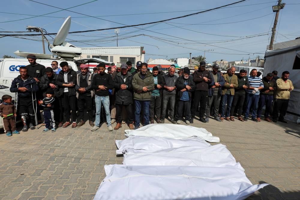 Mourners pray next to the bodies of Palestinians killed in Israeli strikes, at Al-Aqsa Martyrs hospital, in Deir Al-Balah in the central Gaza Strip, on Tuesday. REUTERS