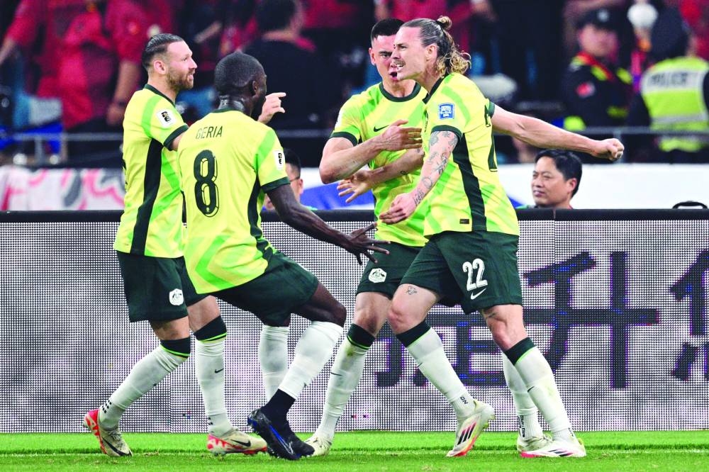 Australia’s Jackson Irvine (right) celebrates with teammates after scoring a goal during the 2026 FIFA World Cup qualification match against China in Hangzhou on Tuesday. (AFP)