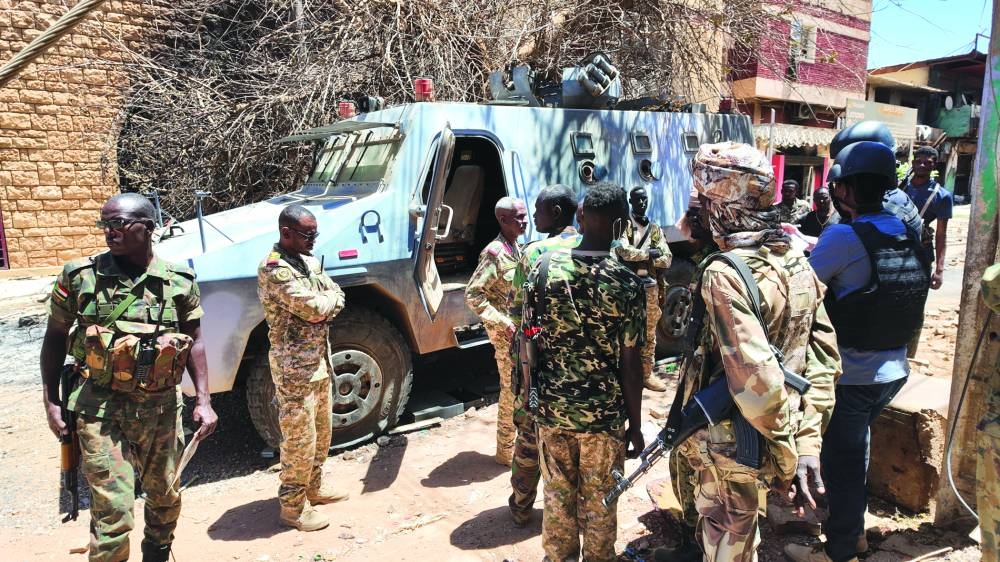 
Members of the Sudanese army gather next to a destroyed military vehicle after a battle with Rapid Support Forces in the capital Khartoum on Tuesday. (Reuters) 