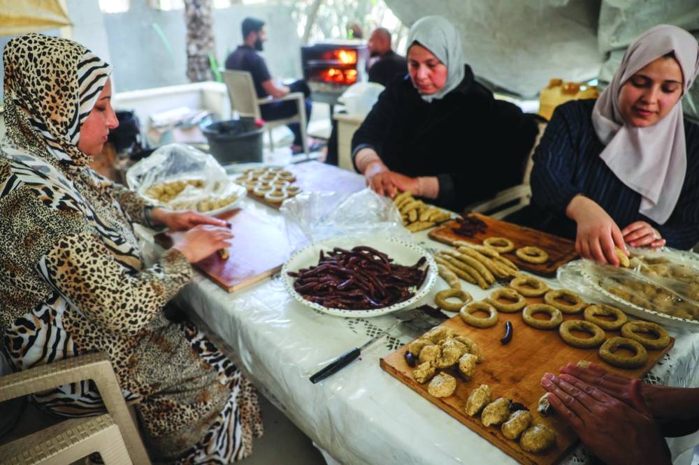 Palestinians make traditional cookies to be distributed  during the upcoming Eid al-Fitr in Bureij in the central Gaza Strip on Thursday 