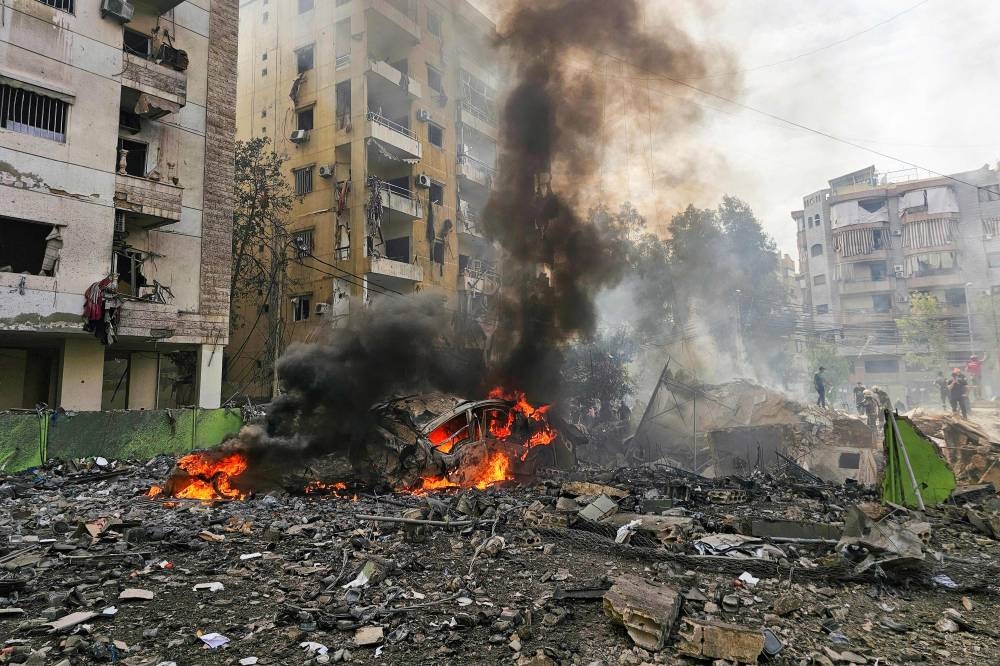 People inspect the site of an Israeli strike in southern Beirut, on Friday. AFP