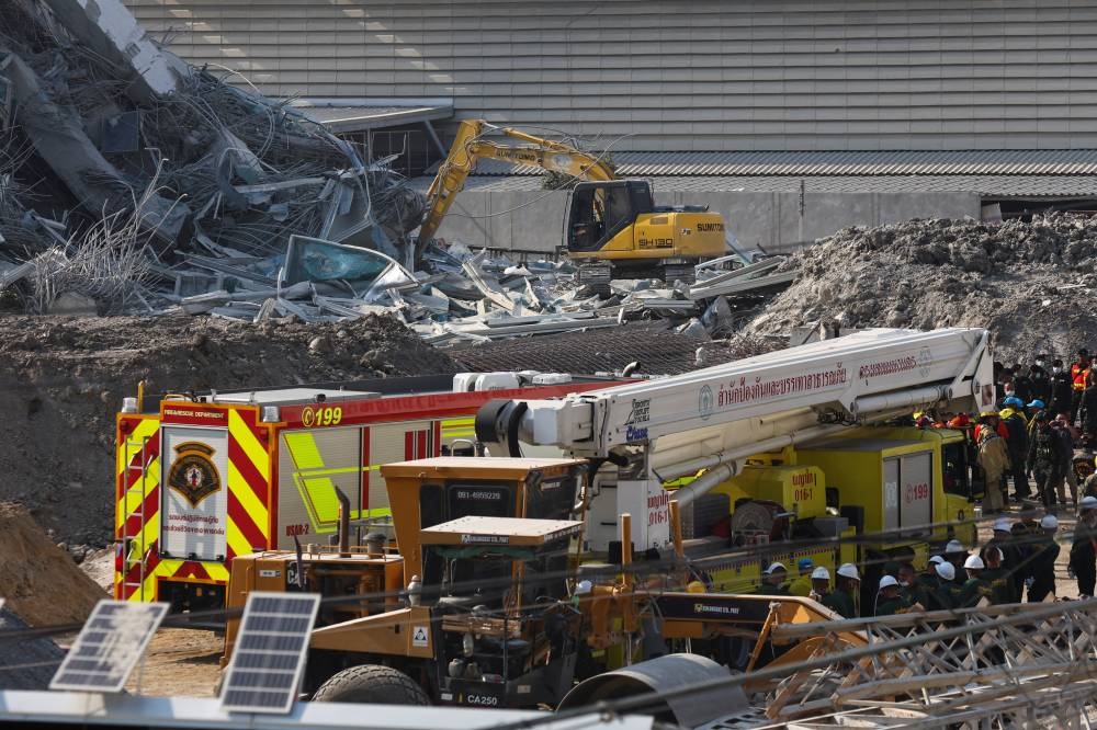 Rescue personnel stand near a building that collapsed after a strong earthquake struck central Myanmar on Friday, earthquake monitoring services said, which affected Bangkok as well with people pouring out of buildings in the Thai capital in panic after the tremors, in Bangkok, on Friday. REUTERS