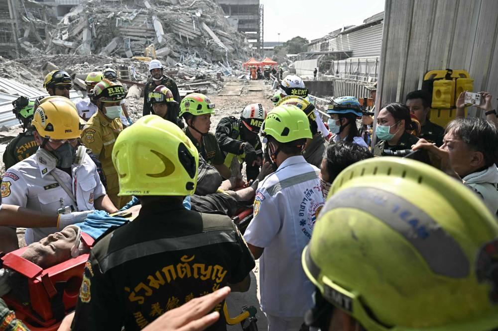 An injured man is rescued at a construction site where a building collapsed in Bangkok on Friday, after an earthquake. AFP