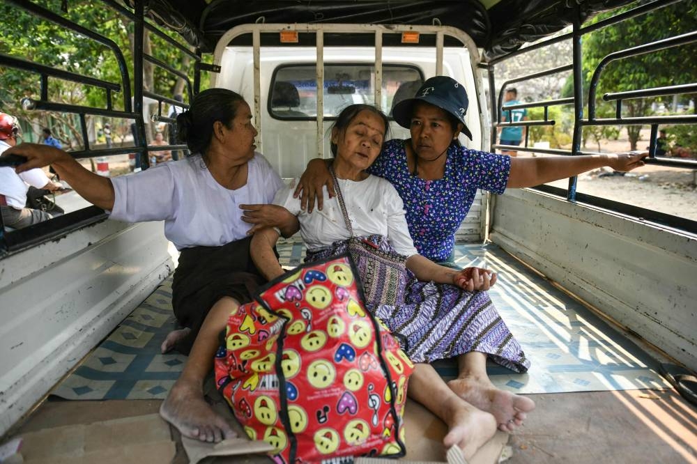 A survivor reacts as she is brought in the back of a lorry to a hospital in Naypyidaw on Friday, after an earthquake in central Myanmar. AFP