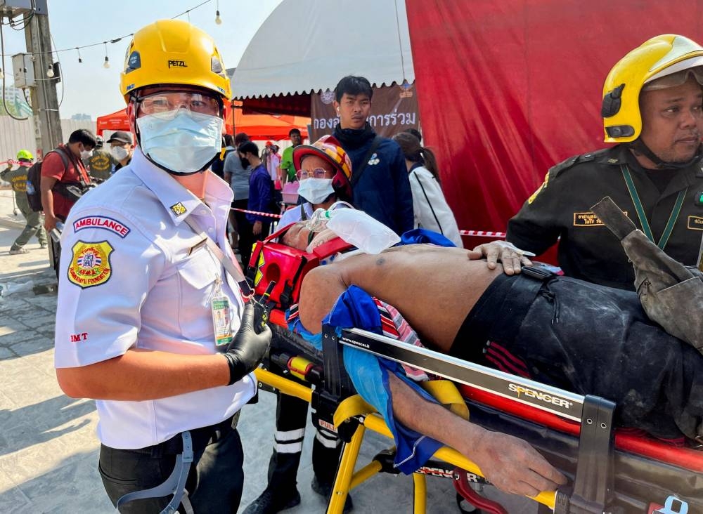 An injured person is stretchered out by emergency personnel near the site of a collapsed building after a strong earthquake struck central Myanmar on Friday, earthquake monitoring services said, which affected Bangkok as well with hundreds of people pouring out of buildings in the Thai capital in panic after the tremors, in Bangkok, Thailand, on Friday. REUTERS
