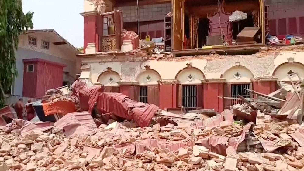 People stand near a collapsed temple following an earthquake in Mandalay, Myanmar,on Friday, in this screengrab taken from social media video. Social Media /via REUTERS 