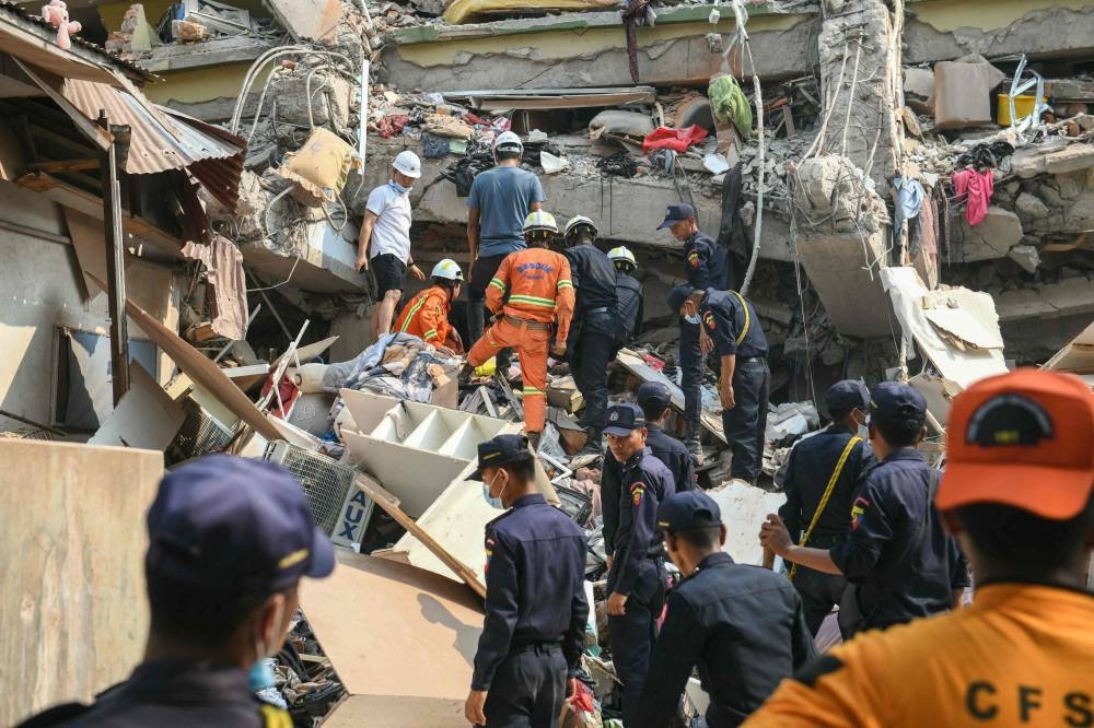 Rescue teams work to save residents trapped under the rubble of the destroyed Sky Villa Condominium development in Mandalay on Saturday. AFP