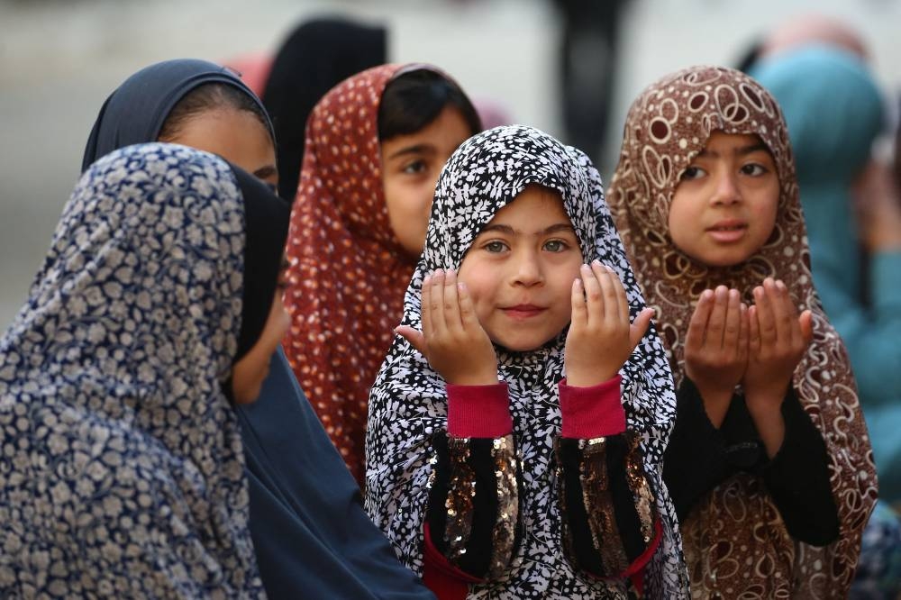Palestinians attend Eid al-Fitr prayers, which marks the end of the holy fasting month of Ramadan, in the Nuseirat camp for Palestinian refugees in the central Gaza Strip, on Sunday. AFP