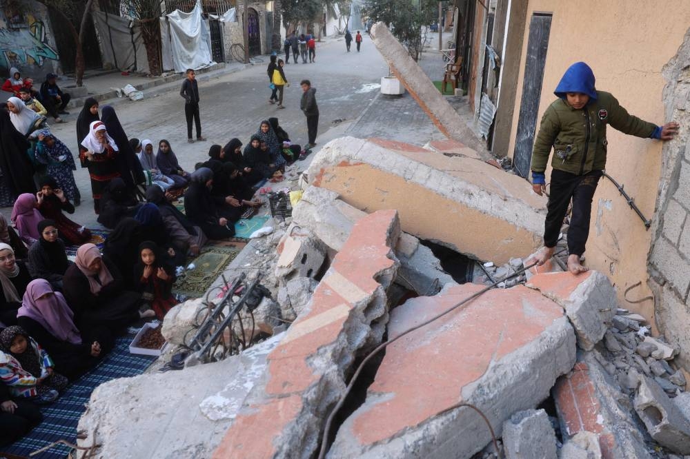 Palestinians attend Eid al-Fitr prayers, which marks the end of the holy fasting month of Ramadan, in the Nuseirat camp for Palestinian refugees in the central Gaza Strip, on Sunday. AFP