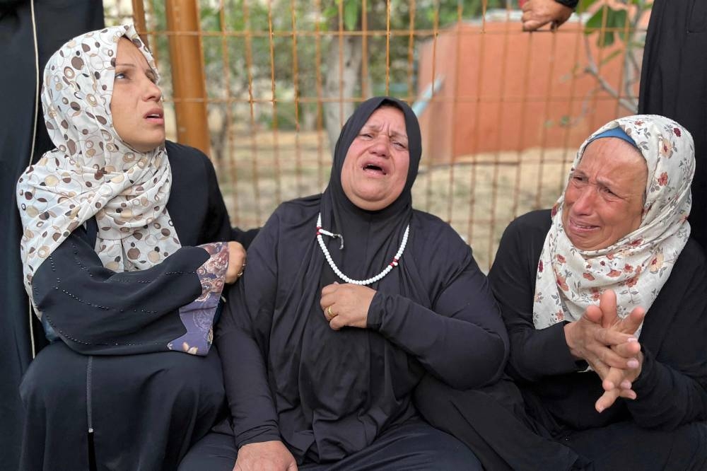 Women gather in mourning outside Nasser Medical Complex in Khan Yunis in the southern Gaza Strip on Sunday as the bodies of Palestinian first responders who were killed a week before in Israeli military fire on ambulances arrive at the facility.  AFP
