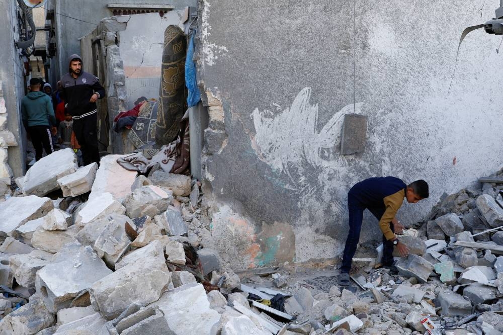 Palestinians inspect the site of an Israeli strike on a house, in Khan Younis in the southern Gaza Strip, on Monday. REUTERS