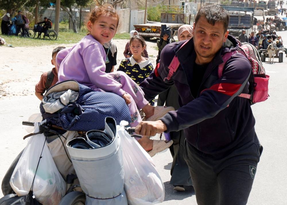 Palestinians make their way after fleeing areas around the southern city of Rafah, following an Israeli evacuation order, in Khan Younis in the southern Gaza Strip, on Monday. REUTERS