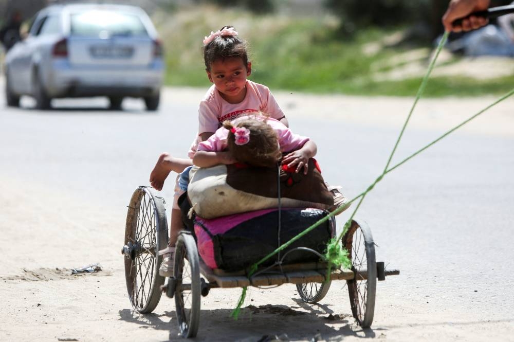 Children travel on a makeshift cart, as Palestinians make their way after fleeing areas around the southern city of Rafah, following an Israeli evacuation order, in Khan Younis in the southern Gaza Strip, on Monday. REUTERS
