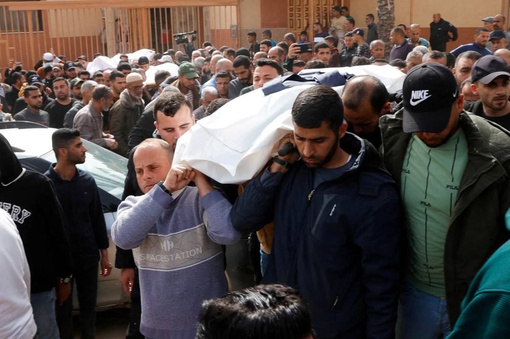 Mourners carry the body of local Palestinian journalist Mohammed Al-Bardawil, who was killed in an Israeli strike, at Nasser hospital, in Khan Younis, in the southern Gaza Strip on Tuesday. REUTERS