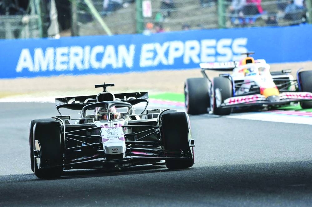 
Red Bull Racing’s Dutch driver Max Verstappen (left) leads RB’s French driver Isack Hadjar during the qualifying session of the Japanese Grand Prix at the Suzuka circuit yesterday. Right: Max Verstappen is presented with a trophy by Jean Alesi. (AFP/ Reuters) 