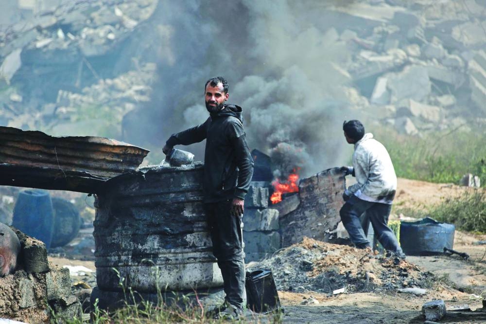 Palestinians work at a makeshift plant extracting fuel from recycled plastic in Jabalia in the northern Gaza Strip on Sunday 