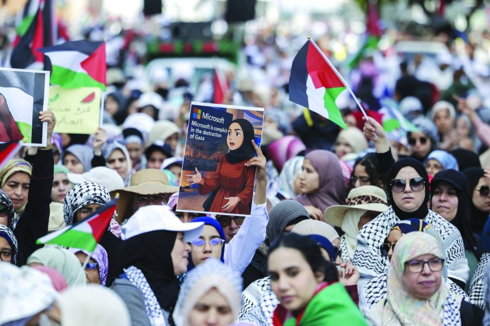 A protester lifts a placard bearing a depiction of Moroccan Microsoft engineer Ibtihal Abu Al-Saad who protested the US company's reported supply of AI technology to Israel in its ongoing war in Gaza, during a national march in support of Palestinians, in Rabat on sunday