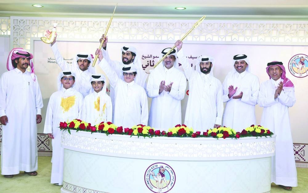 Connections of the winning camels pose with their trophies during the Purebred Arabian Camel Racing Festival at the Al Shahaniyah Racetrack on Wednesday.