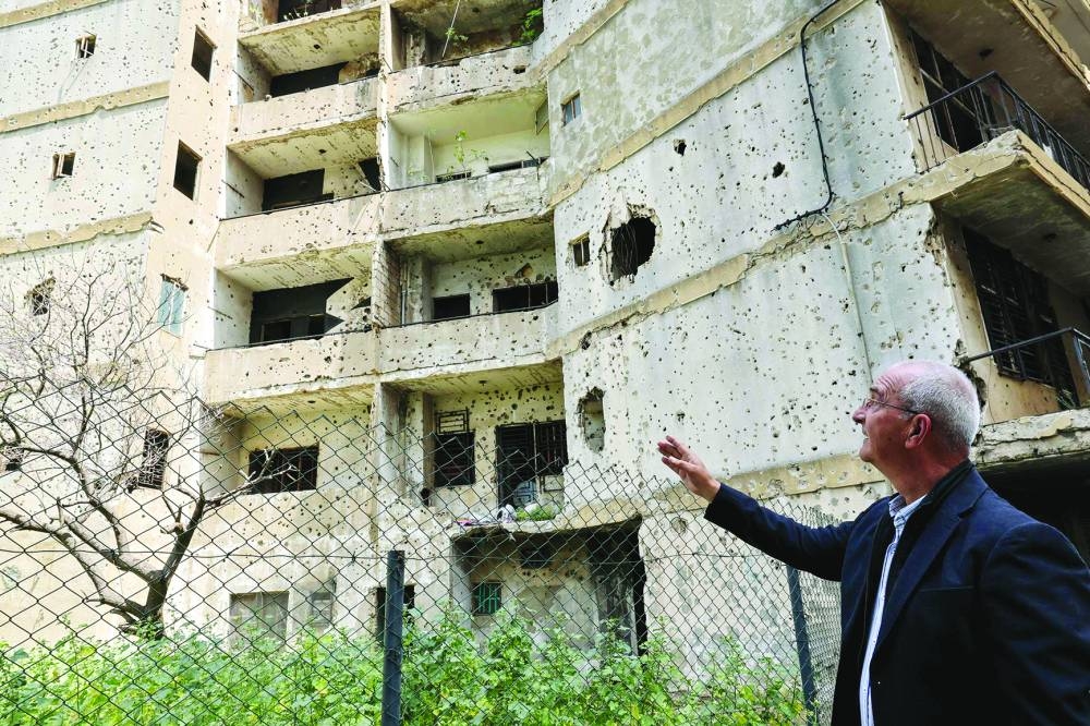 Christian Phalangist Party veteran fighter Joseph al-Asmar points to a bullet-riddled building on the former Green Line area in Ain Al Remmaneh district in Beirut's southern suburbs.
