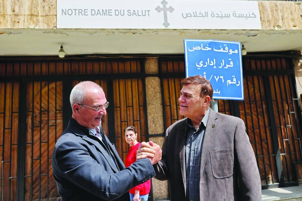 Christian Phalangist Party veteran fighters Joseph al-Asmar (left) and Naji Boutros greet each other as they revisit the Notre Dame Du Salut Church in Ain Al Remmaneh district in Beirut's southern suburbs.