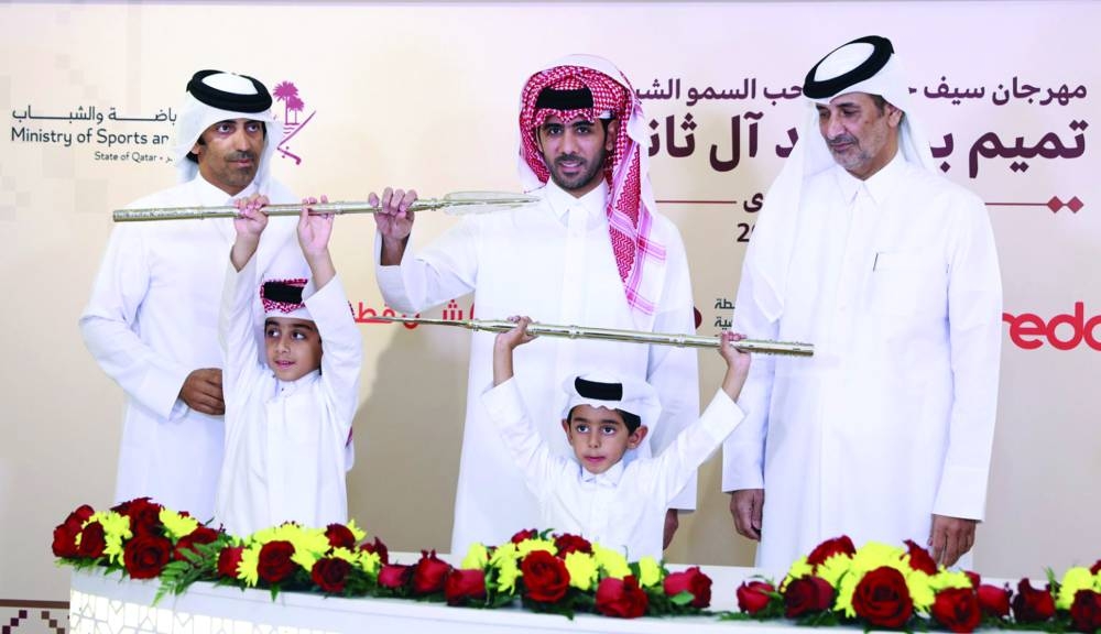 Connections of the winning camels pose with their trophies during the Purebred Arabian Camel Racing Festival at the Al Shahaniyah Racetrack yesterday.