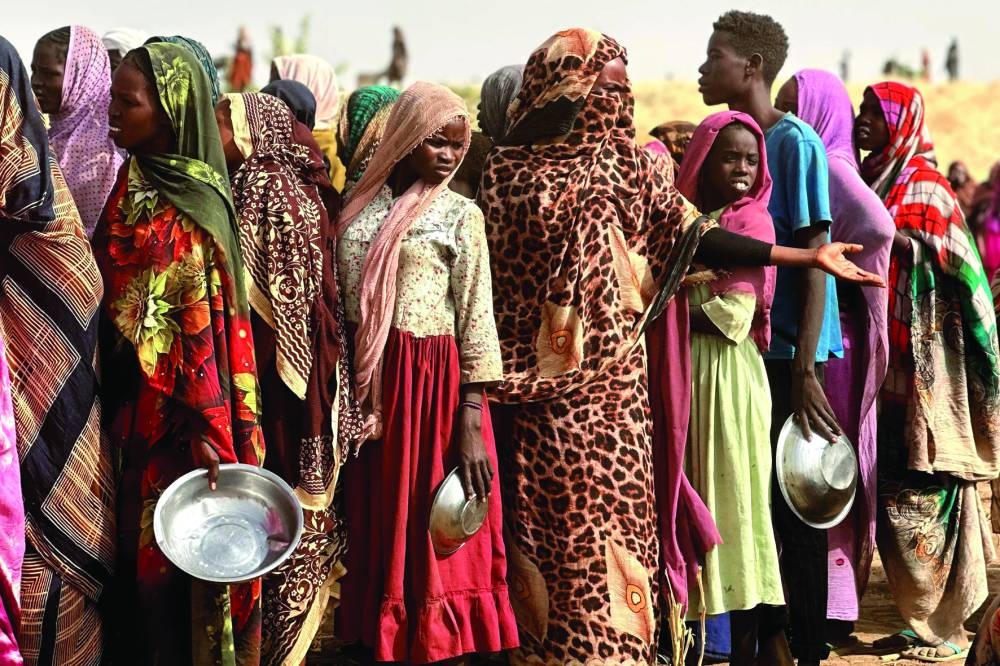 
People who fled the Zamzam camp for the internally displaced after it fell under RSF control, queue for food rations in a makeshift encampment in an open field near the town of Tawila in war-torn Sudan’s western Darfur region on April 13. Sudan’s paramilitary Rapid Support Forces (RSF) announced on April 13 that it had taken control of the famine-hit Zamzam camp, home to over 500,000 refugees according to the United Nations, after two days of heavy shelling and gunfire, amid its ongoing war with the country’s army and affiliated forces. 