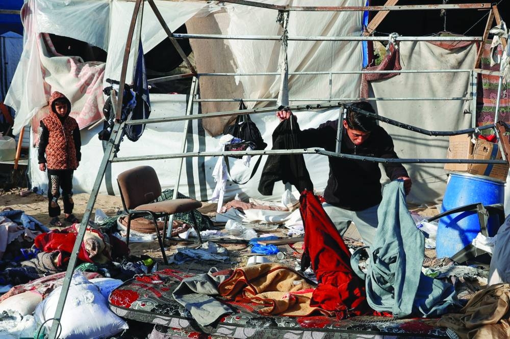 Palestinians inspect the damage at the site of an Israeli strike on a tent sheltering displaced people, in Khan Younis in the southern Gaza Strip, yesterday.