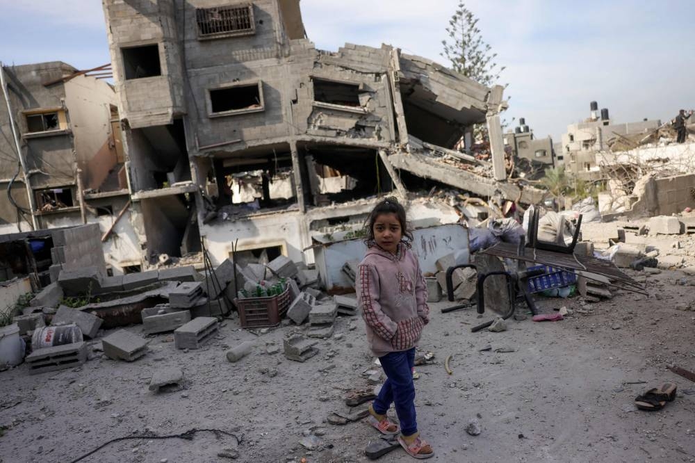 A Palestinian girl walks past a destroyed building in Nazla in the northern Gaza Strip on Wednesday 