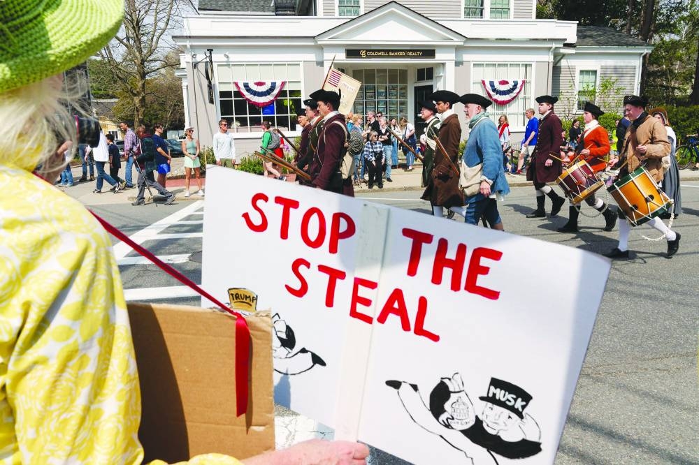 A spectator holds a sign reading ‘Stop the Steal’, in opposition to President Donald Trump and Elon Musk, while watching a parade for the 250th anniversary of the Battle of Lexington and Concord in Concord, Massachusetts. Lexington and Concord – the sites of the first battle of the Revolutionary War that was fought on April 19, 1775 – are hosting reenactments, a parade and other events to mark the anniversary. – Reuters