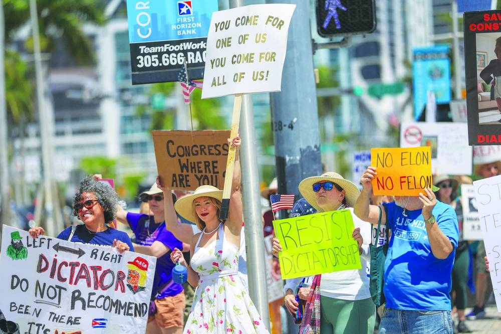 People join together during a protest organised by the 50501 Movement in Miami yesterday. Organisers of the nationwide protest said the demonstrations were to denounce the ‘hostile government takeover’ by the Trump administration. – AFP