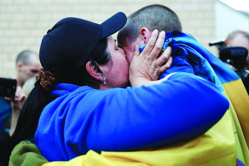 Olha, kisses her son Oleksandr, one of the prisoners of war after he returned following a swap in an undisclosed location in Ukraine yesterday. (Reuters)