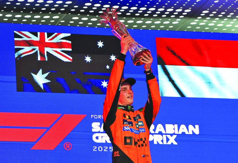 McLaren's Oscar Piastri celebrates with the trophy on the podium after winning the Saudi Arabian Grand Prix  at Jeddah Corniche Circuit on Sunday. (Reuters)