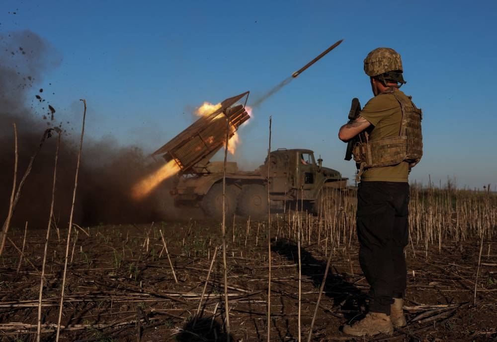 Ukrainian service members fire a BM-21 Grad multiple rocket launch system towards Russian troops near the frontline town of Pokrovsk