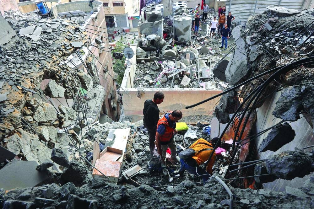 Medics search the rubble following Israeli strikes on apartments in a residential building in Gaza City's Yarmuk street on Thursday 