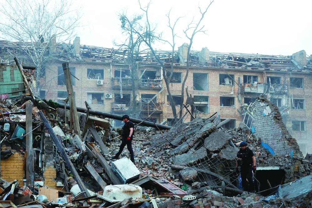 Police officers inspect the site of a building hit by a Russian ballistic missile strike, in Kyiv, on Thursday 